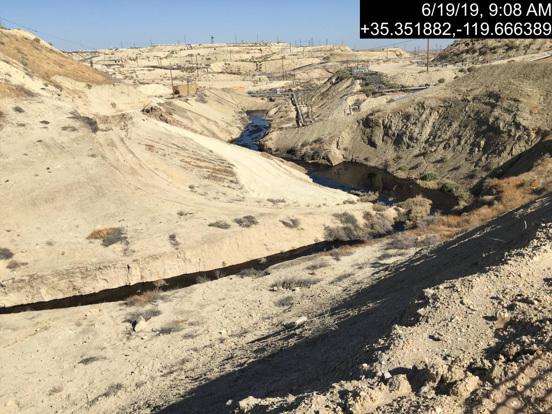 Image showing portion of dry creekbed fouled by oil spill at a Chevron well site in Kern County.  California Department of Conservation