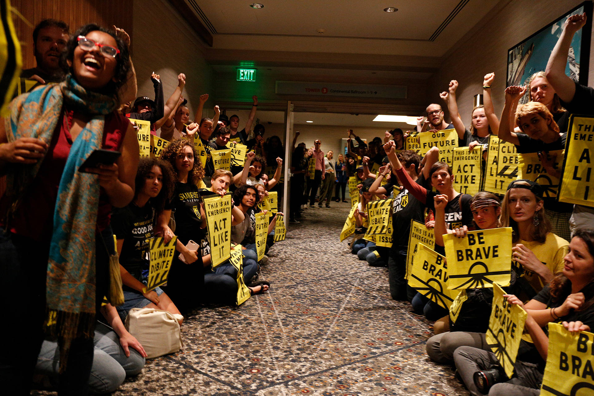 Protesters with the Sunrise Movement urge party leaders to host a single-issue debate on climate change at the Democratic National Committee meeting at the Union Square Hilton in San Francisco on Aug. 23, 2019. Stephanie Lister/KQED