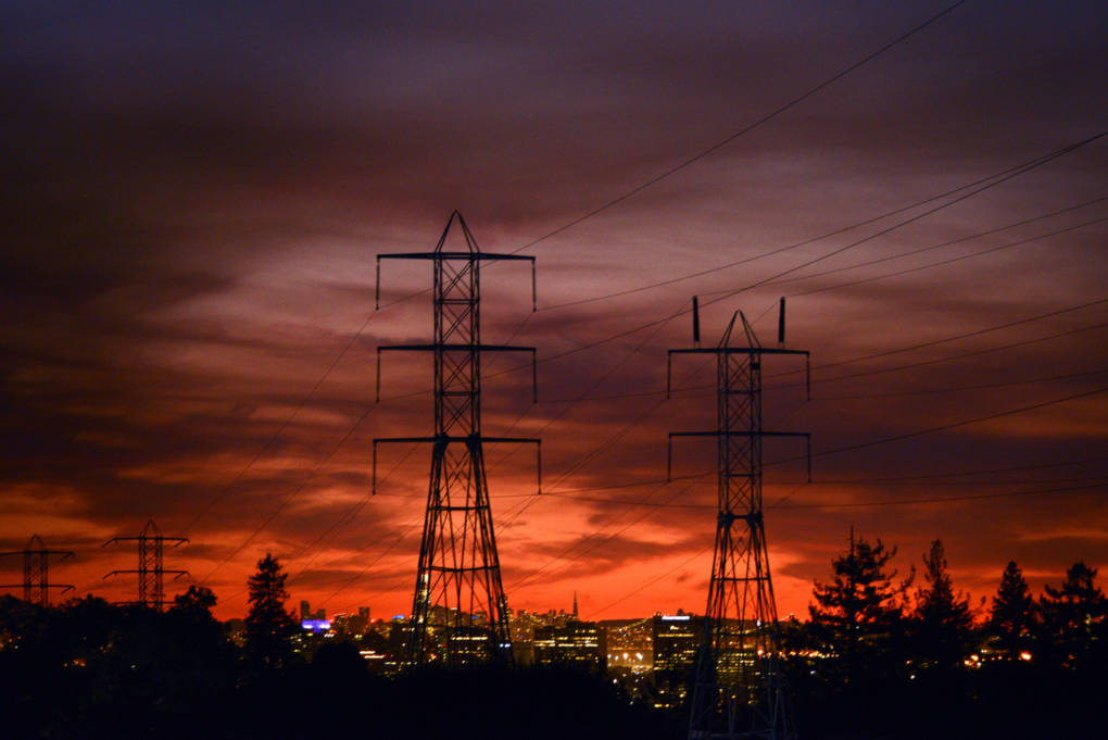 Power lines backlit by a bold orange sunset.