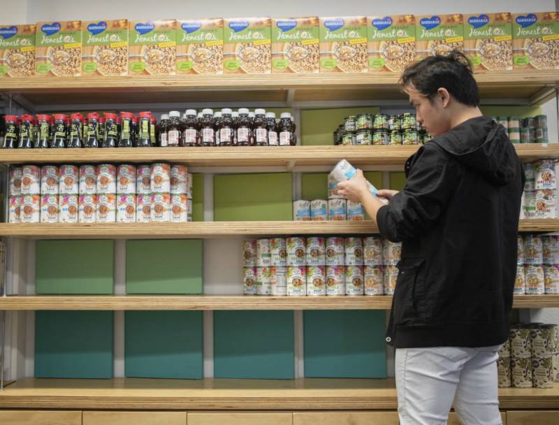 Man restocks shelves with canned food