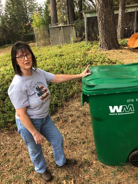 Kathy Lafayette stands next to a garbage receptacle full of mulch from her mother's yard in Grass Valley. The family spent more than $3,000 fire proofing their property this year and still lost their coverage.
