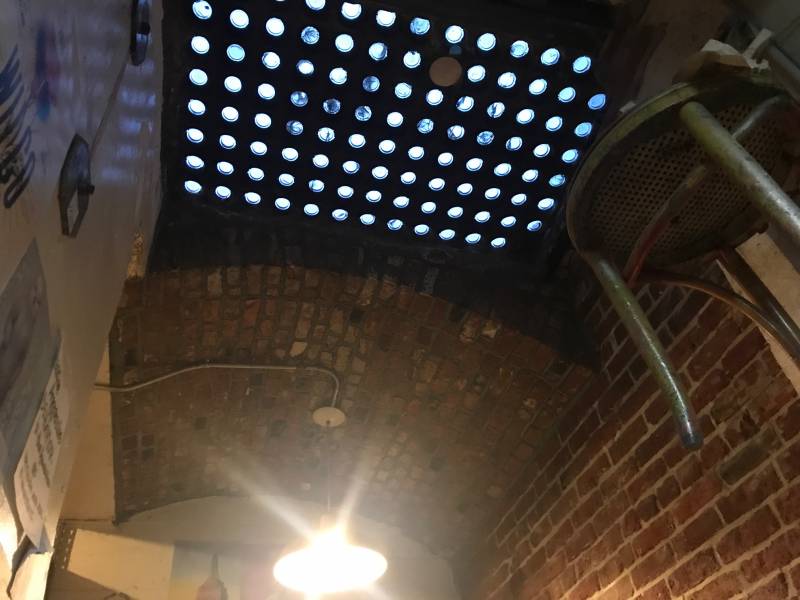 Beneath a vault light inside a sub-sidewalk basement.