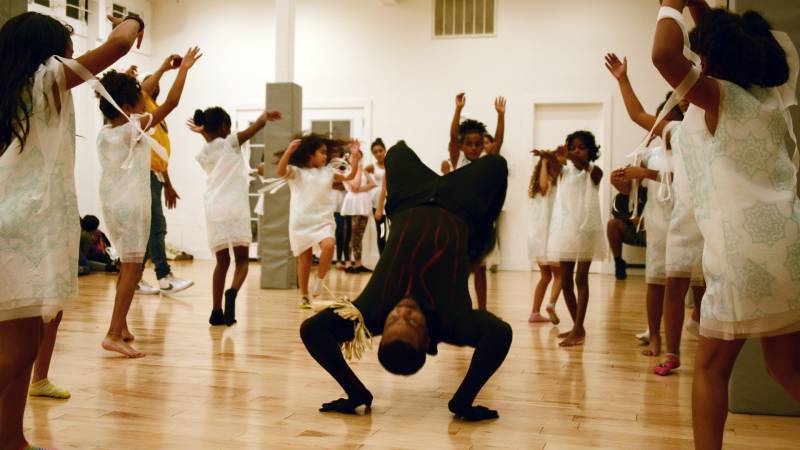 James Davis, who dances Exu, break-dances with a group of snow angels during a rehearsal at Sullivan Community Space in Oakland on Dec. 8, 2019. 