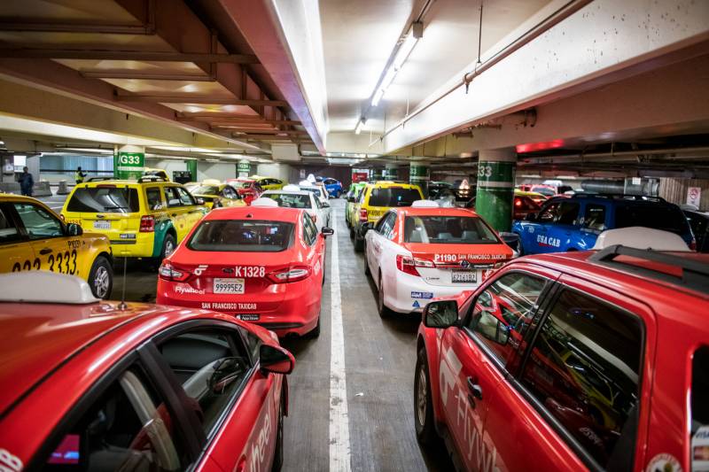 Taxis wait to pick up passengers at San Francisco International Airport on Jan. 30, 2020. With about 500 taxi drivers coming to SFO daily, each driver may get only as few as three rides a day.