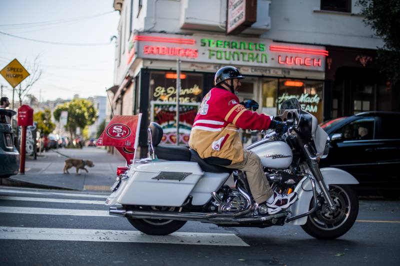 Rolando Gonzalez rides his Harley Davidson down 24th St in the Mission before the start of the Super Bowl on Sunday. 3