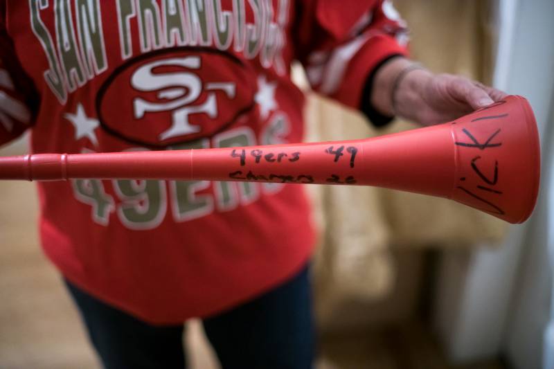 Vickie Arllano holds a horn that she has ready in case the 49ers win the Super Bowl on Sunday. She said she would join her friends and neighbors on Alabama Street even if it can get a little wild, they always look out for her.