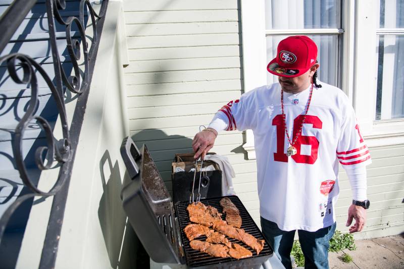 Will Narvaez grills outside of the Carrasco house on Alabama Street before the Super Bowl on Sunday.