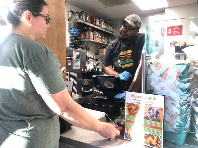 A customer pays with a credit card at Burger Patch, a vegan burger joint in Sacramento.