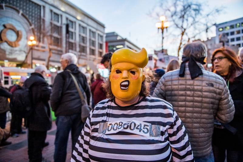 Christine Diehl wears a Trump mask at a protest against the Senate's acquittal of President Trump on two impeachment charges.