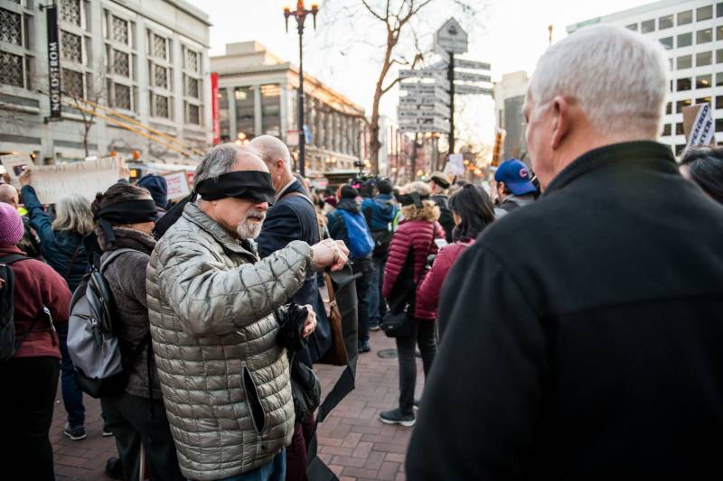 Michael Kesselman hands out blindfolds at the Reject the Coverup protest at Powell and Market Streets in San Francisco on Feb. 5, 2020. He said that justice should be blind but not blinded.