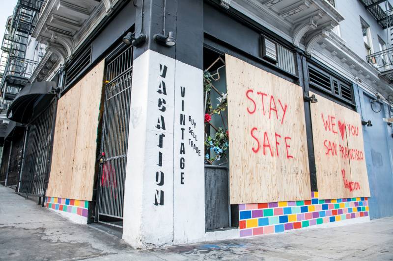 The owners of the vintage clothing store Vacation in the Tenderloin put boards over their windows as they closed their brick and mortar store after shelter-in-place orders were issued on Tuesday, Mar. 17, 2020. They are hopeful that online sales will continue, but worry for the future.