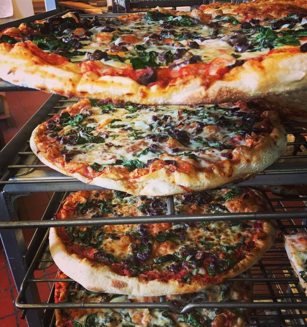 Arizmendi Bakery pizzas cool on a rack.