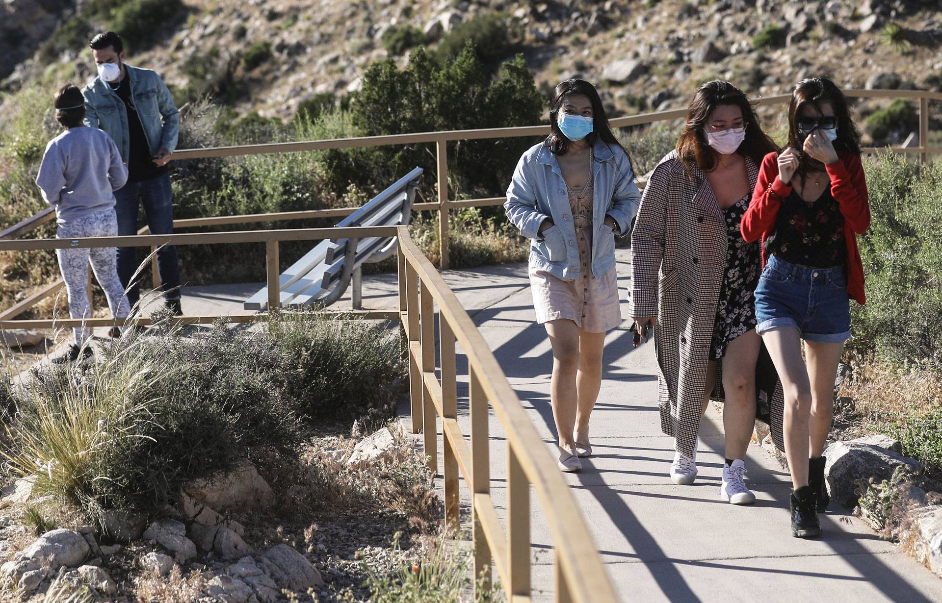 Visitors wear face masks on a walking path in Joshua Tree National Park on May 18, one day after the park reopened after being closed due to the coronavirus pandemic. Mario Tama/Getty Images