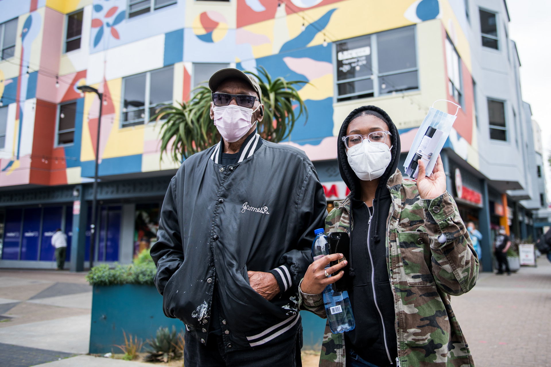Chelsea Riley (right) and her father James Riley line up to receive free hand sanitizer and a face mask in the Fillmore on April 17, 2020.