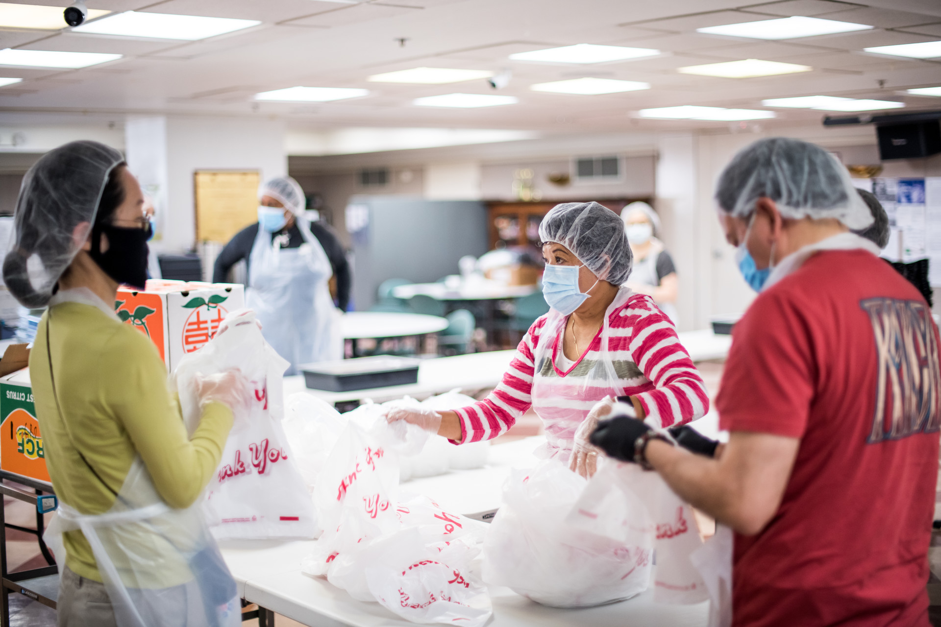 Volunteers and city employees prepare meals at Lady Shaw Senior Center to be delivered to seniors living in Chinatown Community Development Center-owned SROs on April 5, 2020.