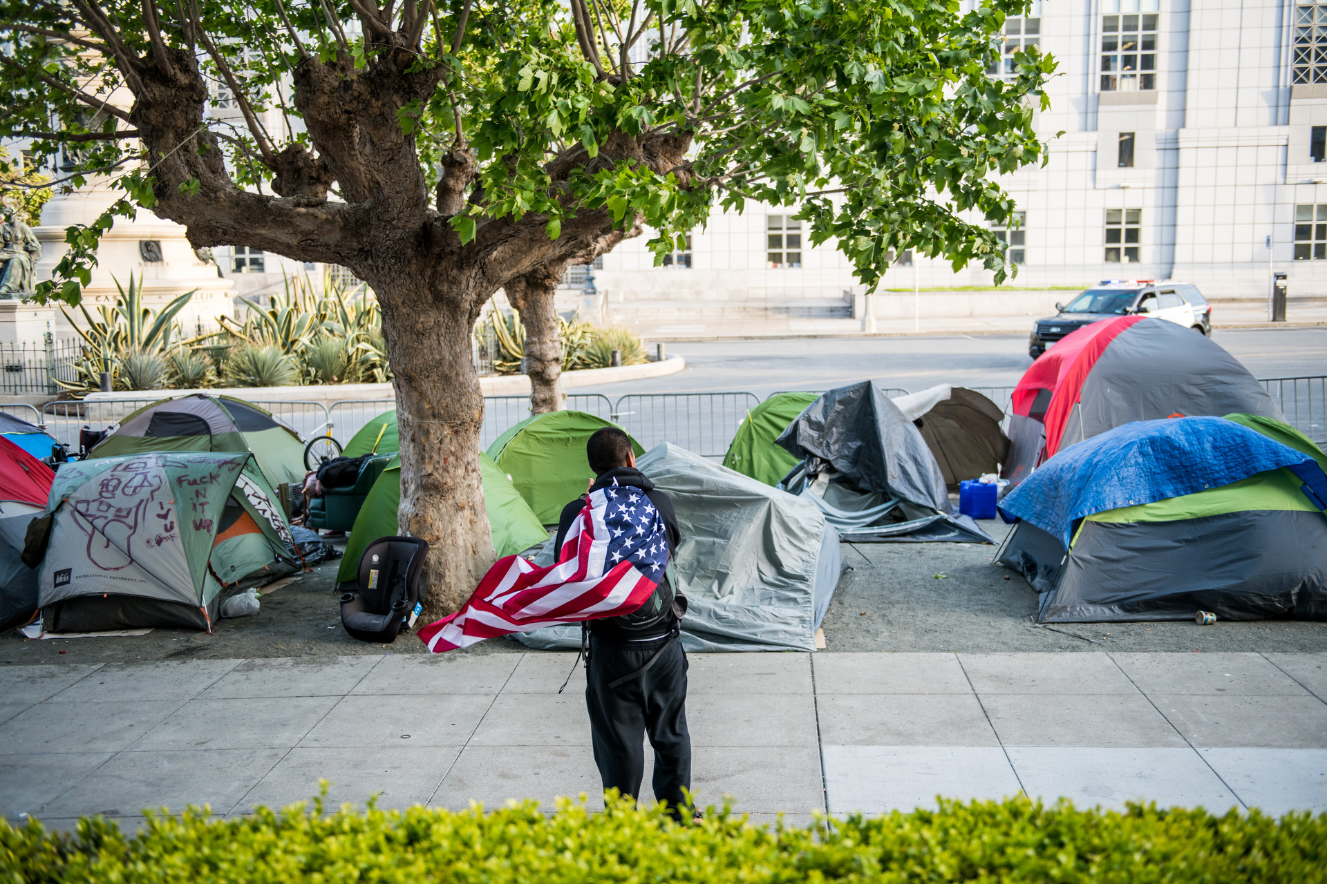Tents line a gravel sidewalk off Fulton Street near City Hall on May 5, 2020. On Wednesday, city staffers started drawing out socially distant spaces with chalk on the street for the tents to stay.