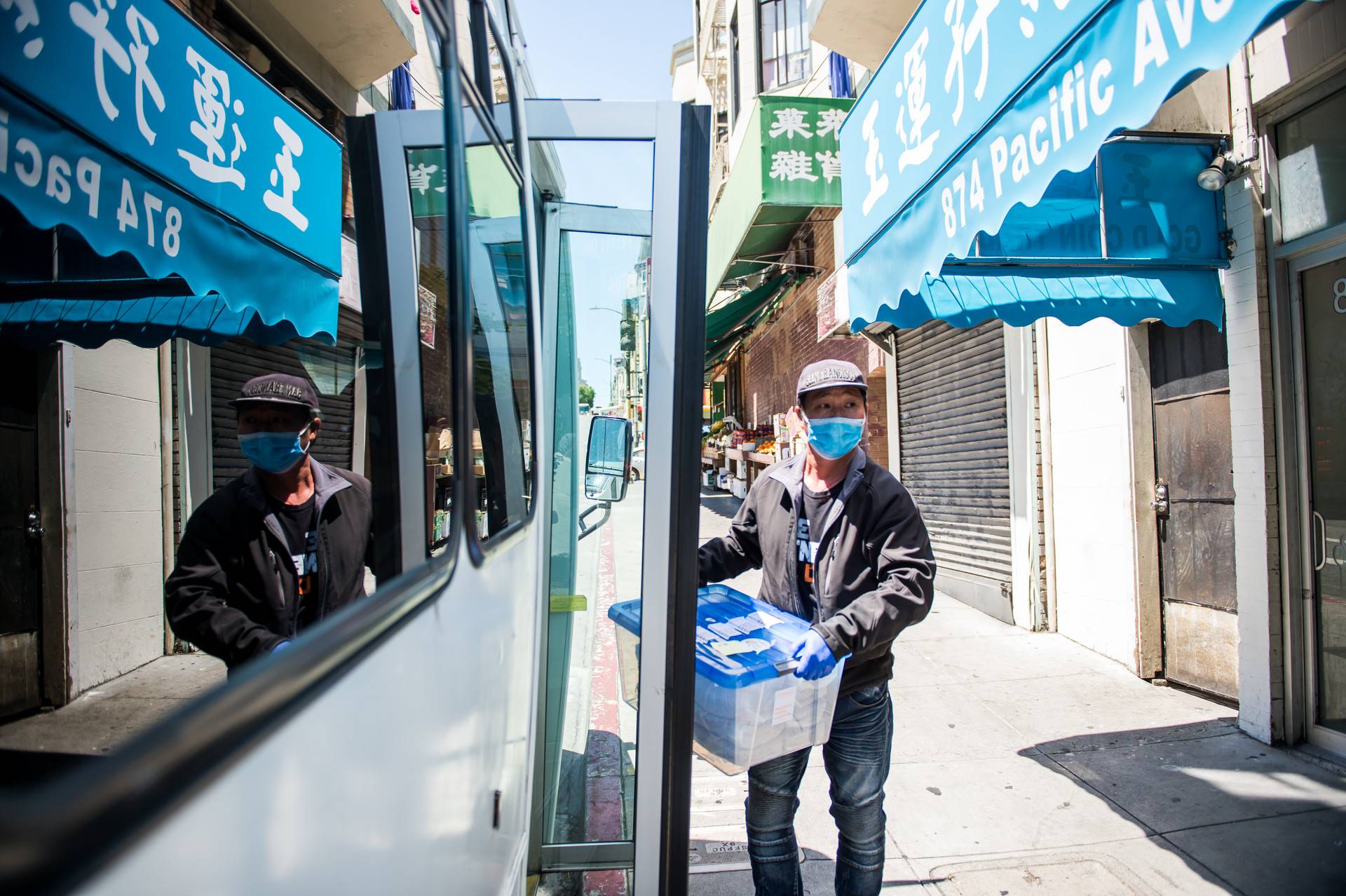 Meals that were prepared at Far East Cafe are brought to Ping Yuen, a public housing building in San Francisco's Chinatown, where employees of a Chinatown nonprofit and volunteers help distribute meals to residents on May 5, 2020. Beth LaBerge/KQED