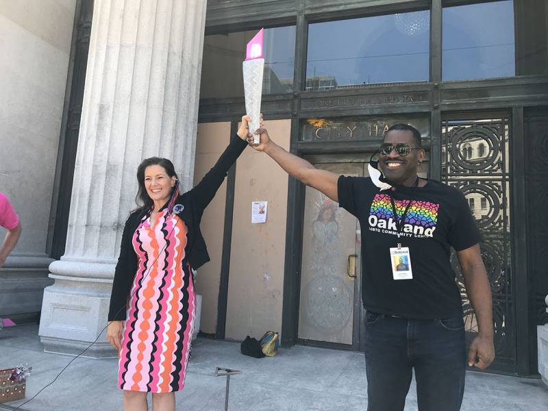 Oakland mayor Libby Schaaf and Joe Hawkins, founder of Oakland Pride and CEO of the Oakland LGBTQ Community Center, hold up the Pink Torch as they kick off the procession outside Oakland City Hall.
