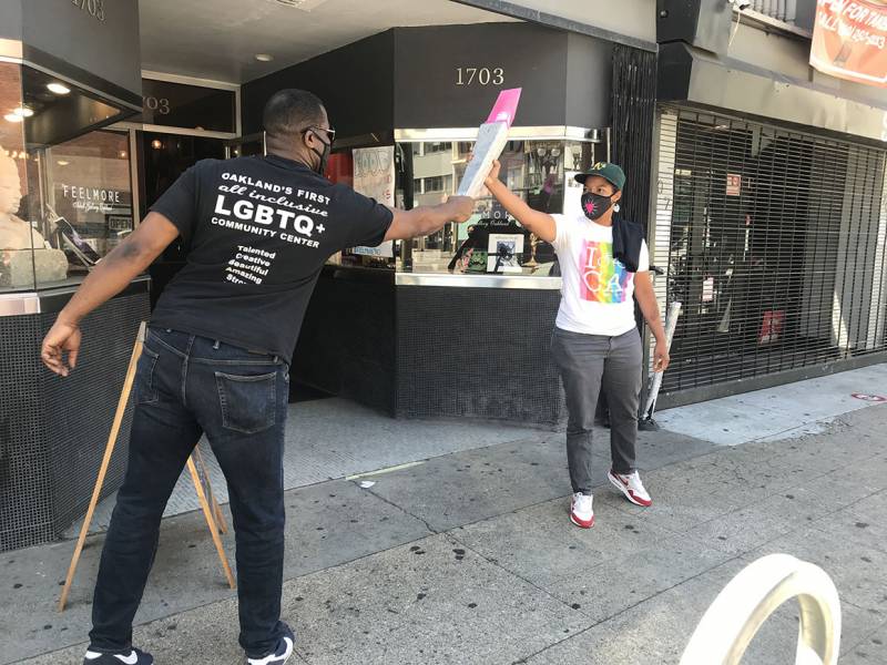Joe Hawkins, founder of Oakland Pride and CEO of the Oakland LGBTQ Community Center, passes off the Pink Torch to Nenna Joiner, owner of sex toy shop Feelmore in downtown Oakland.