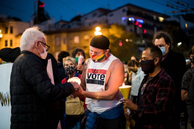 Stephan Ferris lights a candle for Cleve Jones during a vigil to honor the life of Ruth Bader Ginsburg in the Castro on Sep. 18, 2020.