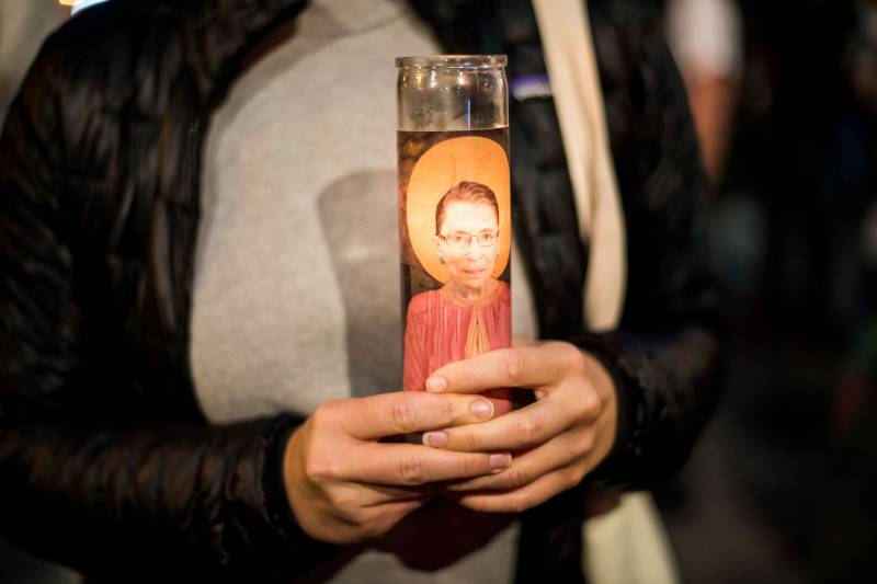 Gillian Reid holds a Ruth Bader Ginsburg candle during a vigil in her honor in the Castro on Sep. 18, 2020.