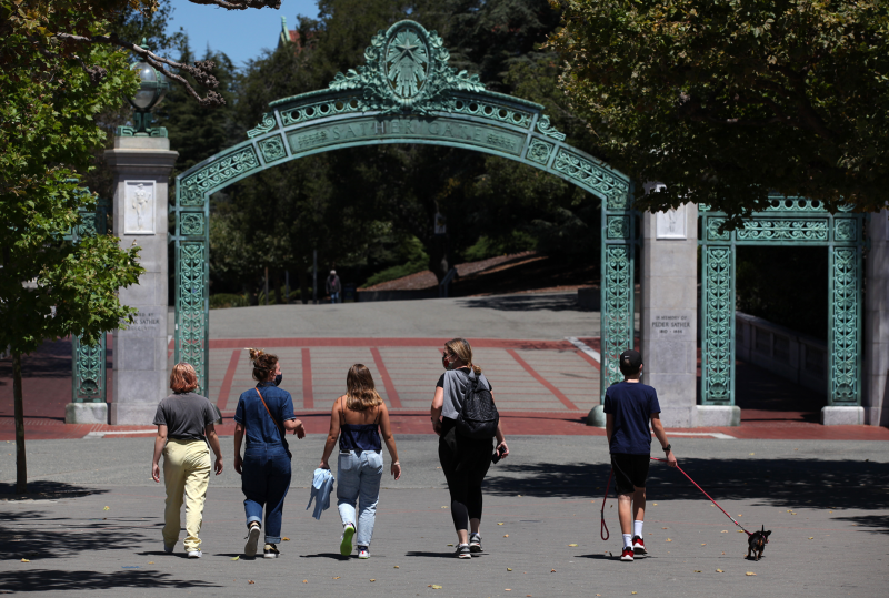 Students wearing masks at UC Berkeley walk through Sather Gate