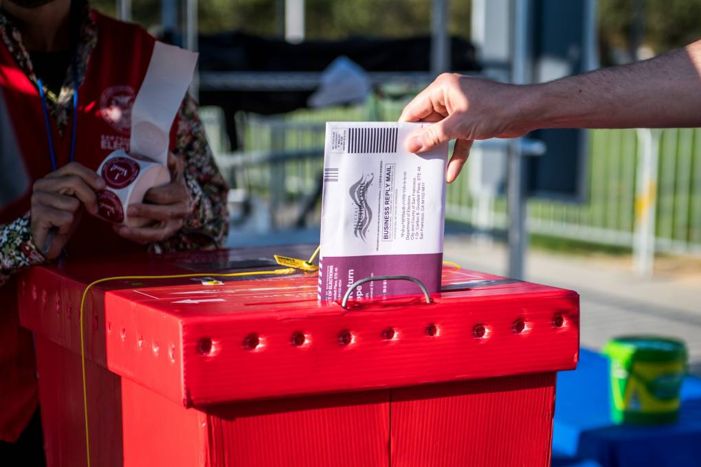 A voter drops off a ballot at a new outdoor voting center near Civic Center Plaza in San Francisco on Oct. 5, 2020, the first day of early voting. Beth LaBerge/KQED