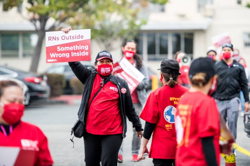 Alameda Health System employees and supporters march outside of Alameda Hospital on Oct. 7, 2020, during a planned five-day strike over COVID-19 safety concerns and stalled contract negotiations.