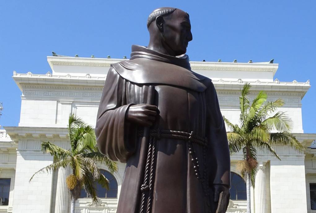 A bronze figure of the 18th century missionary Junípero Serra stands outside Ventura City Hall, sculpted in 1936 by Uno John Palo Kangas. Indigenous activists say a reckoning with Serra's legacy is long overdue. Cbl62/Wikimedia Commons