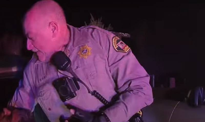 A screenshot of a body camera video showing a sheriff's deputy at night.