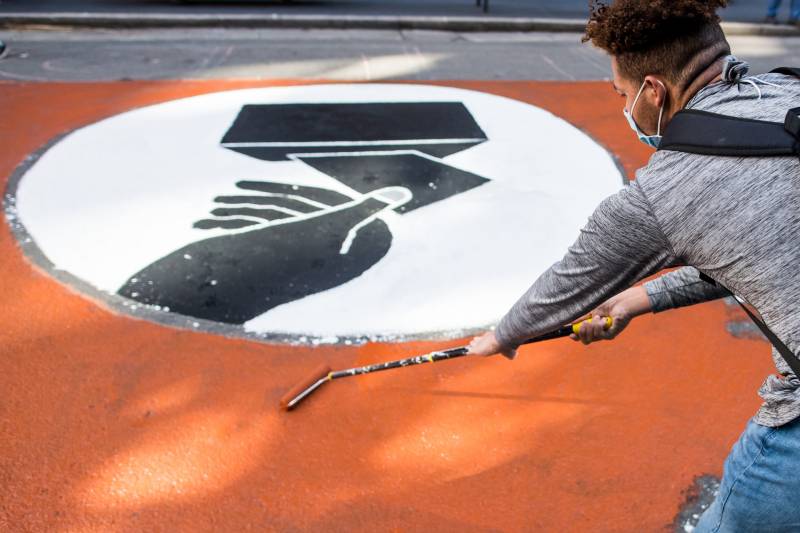 Miguel Davis paints a "Count Every Vote" mural on the pavement of Montgomery Street in San Francisco on Nov. 6, 2020.
