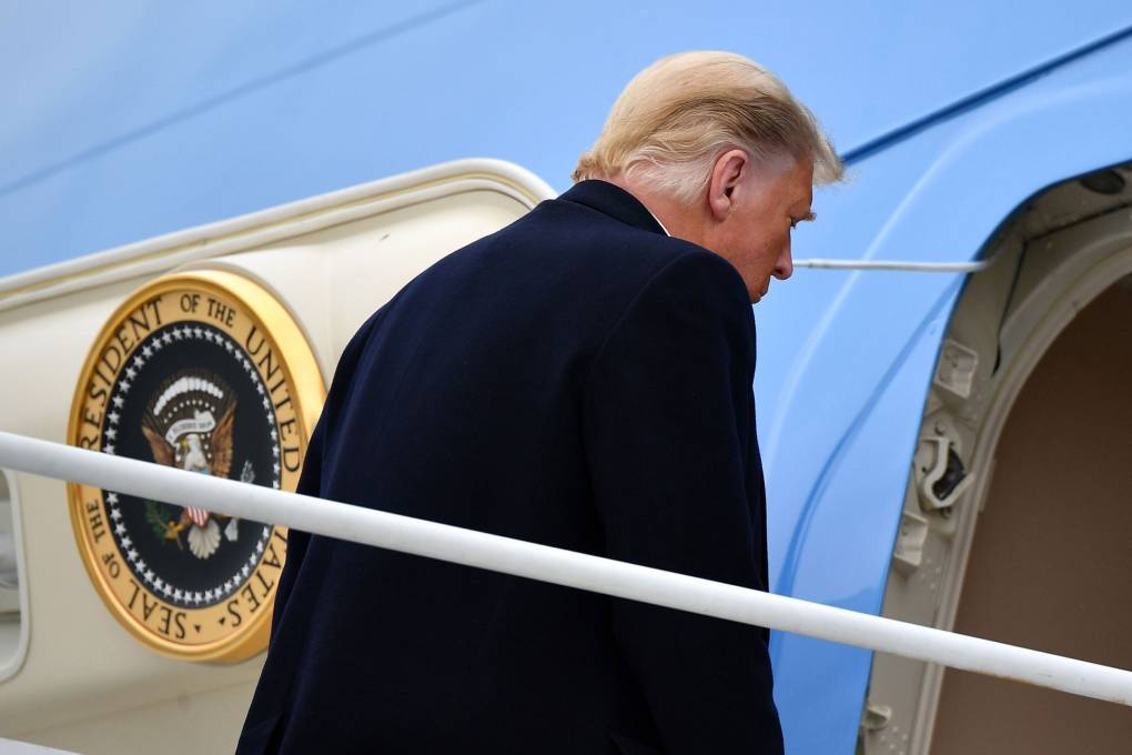 Trump, back turned, walks into Air Force One