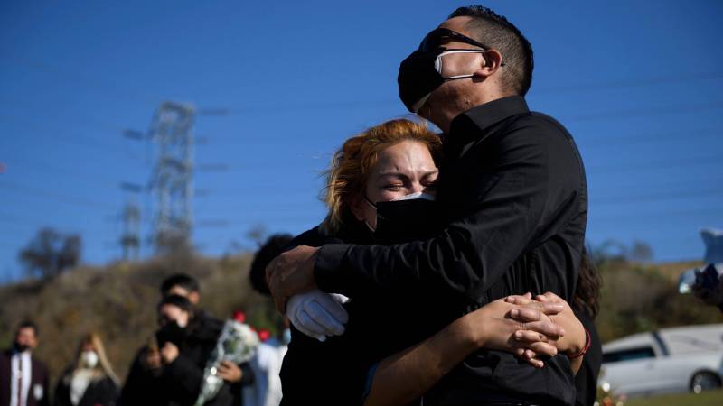 Maricela Arreguin Mejia (L) and her brother Nestor Arreguin mourn the death of their father Gilberto Arreguin Camacho, 58, due to COVID-19 during his burial at a cemetery on New Year's Eve, December 31, 2020.