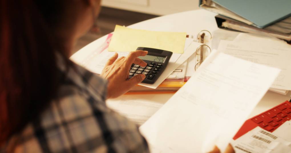 woman doing taxes with calculator