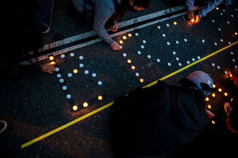Demonstrators light candles that spell Breonna Taylor's name in front of the Mission Police Station in San Francisco on March 13, 2021, one year after Taylor was fatally shot by police officers in Kentucky.