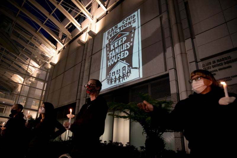 Housing activists and rent strikers participate in a vigil for tenants who they say will not be covered by Gov. Gavin Newsom’s rent relief plan at the Elihu M. Harris, State of California office building in Oakland on Jan. 29, 2021. 