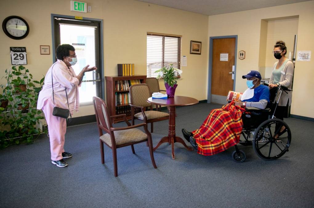 Ouida Dill, left, blows a kiss to her husband, David, at the end of their visit at Lincoln Glen Skilled Nursing Facility in San Jose. David has been a resident at Lincoln Glen for more than four years. For the past year, Ouida visited him almost every every day through a window. Now that Ouida is vaccinated, the couple can see each other indoors again.