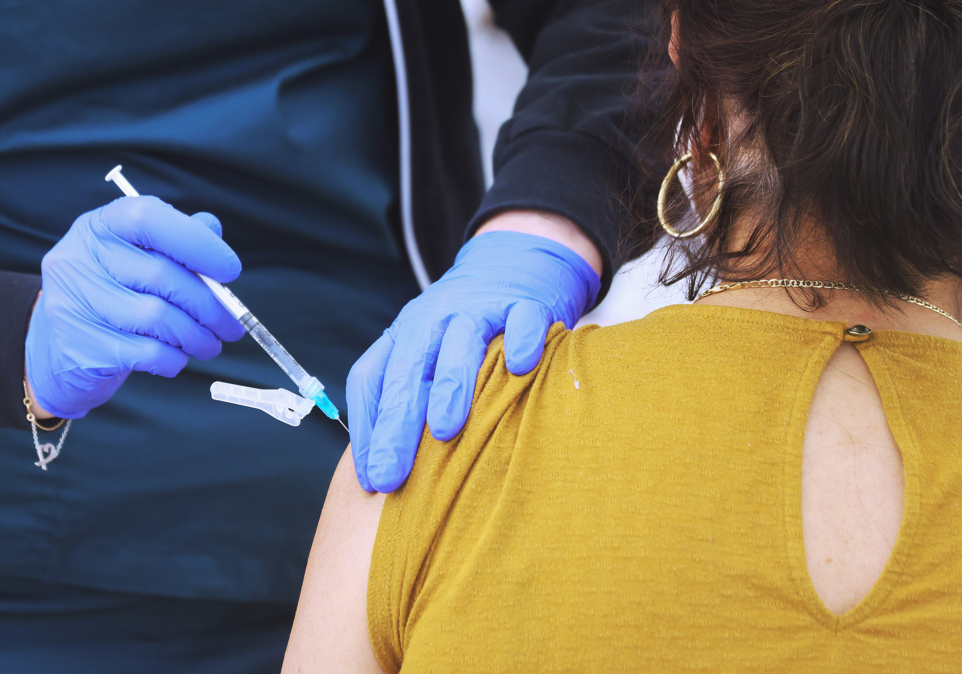 woman getting COVID vaccine dose shot in the arm