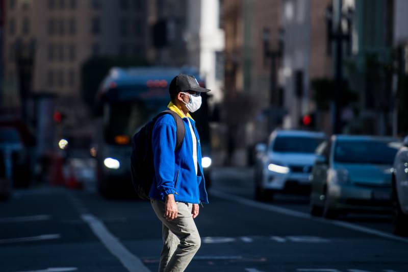 Masked pedestrian crosses SF street
