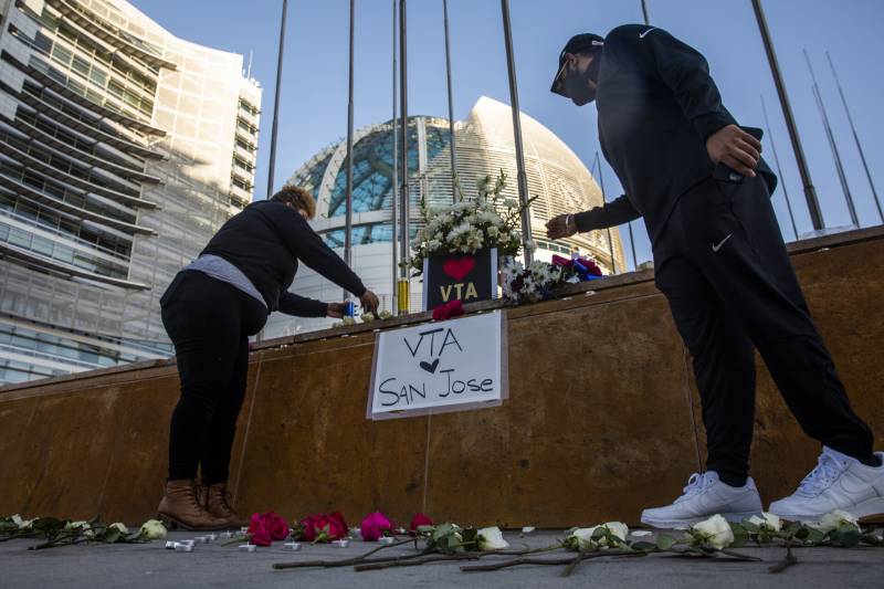 Mourners lay flowers at a vigil for shooting victims