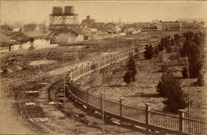 The First Market Street Chinatown in San Jose was built in 1866. In this photo, the towers of McKenzie Iron Foundry, the San Jose Brewery and San Jose waterworks is visible in the background.