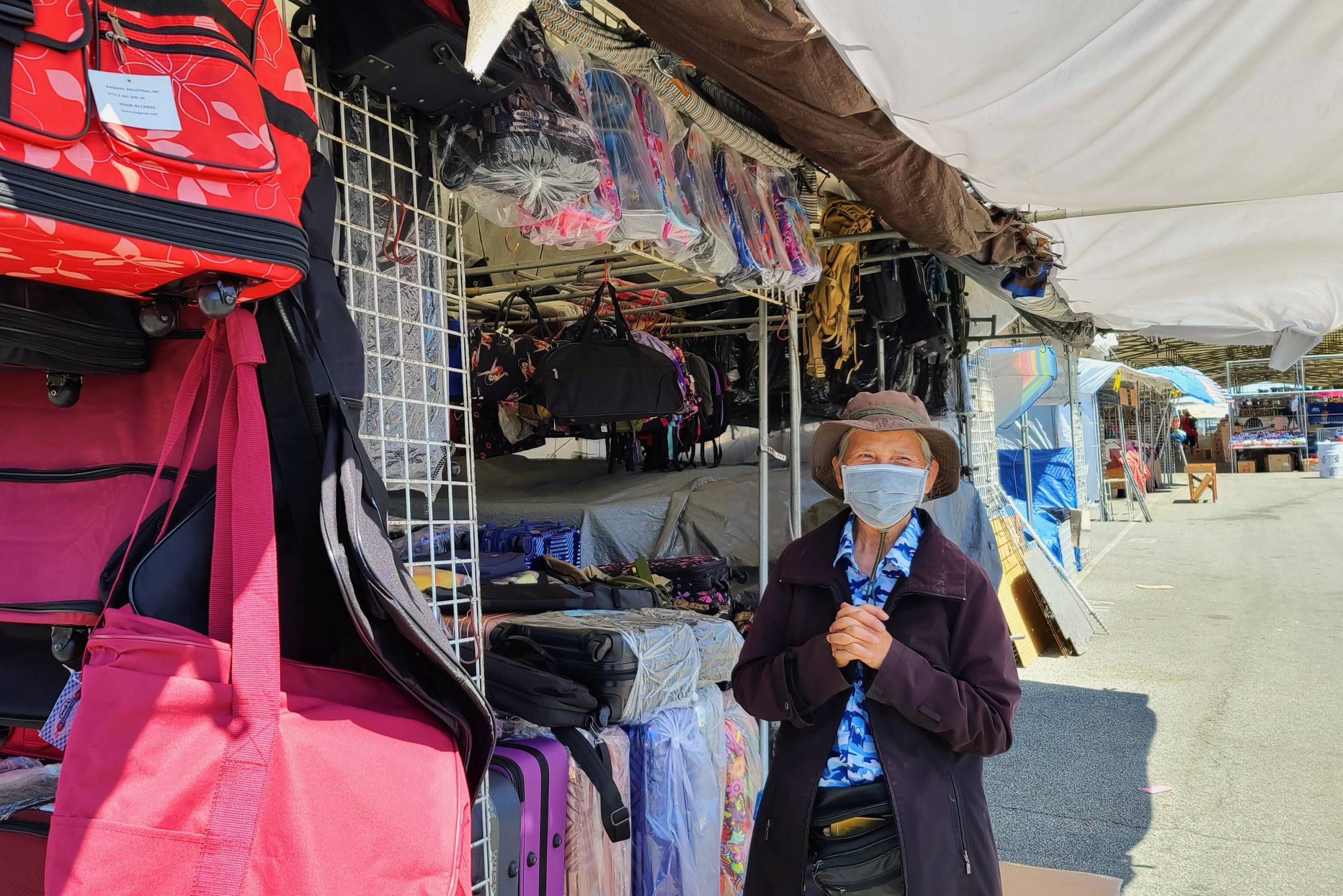 Chau Nguyen stands next to her stall covered in the luggage bags and backpacks she sells.