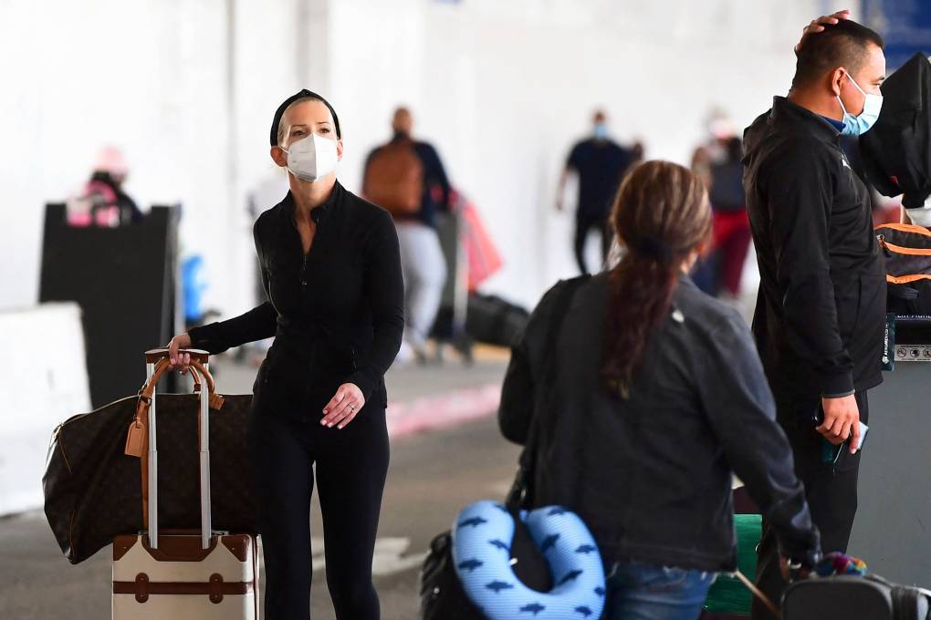 A person wearing a facemask walks through an airport.