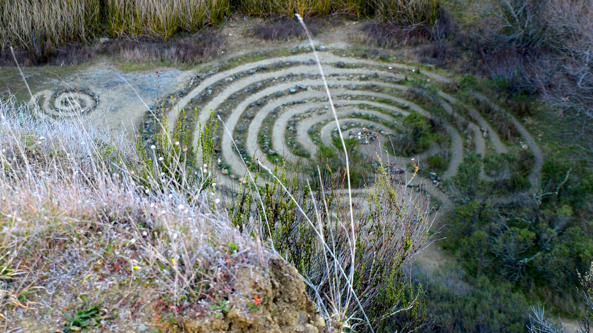 A labyrinth made of grass and stones sits at the bottom of a quarry in Sibley Volcanic Regional Preserve.