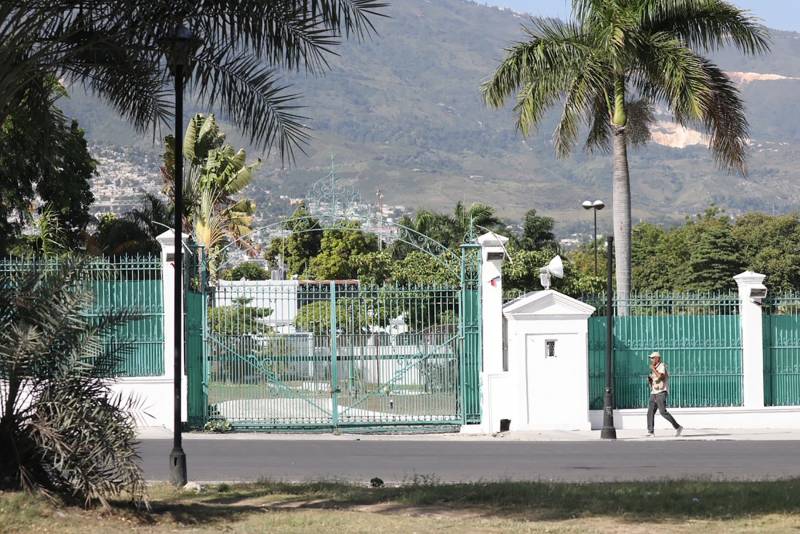 A wide shot of a person walking by themselves in front of the Presidential Palace in Haiti.