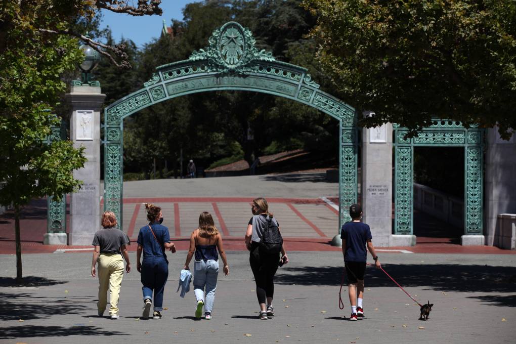 Students walk toward a gate on a college campus.