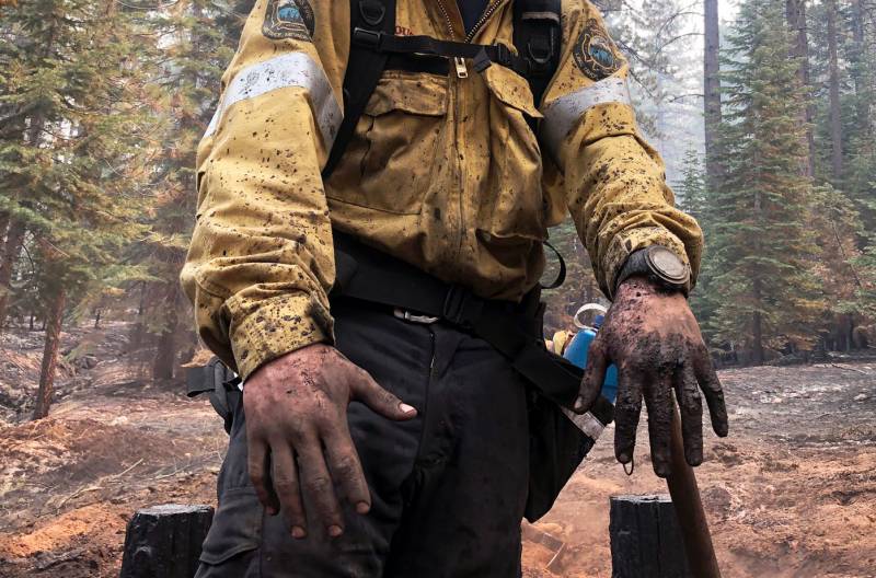 Close-up of a firefighter's dirty hands and clothing.