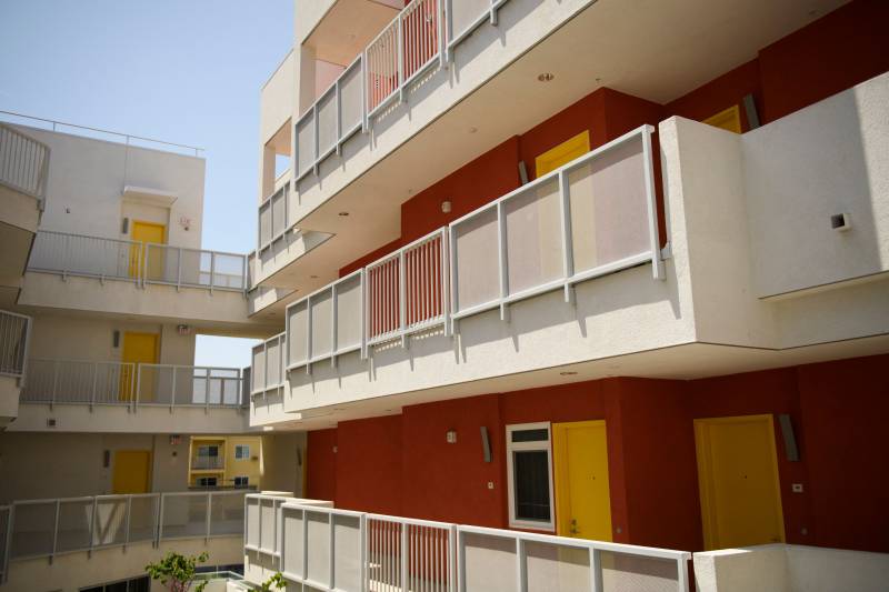 An exterior view of bright, modern-looking balconies on a high rise apartment building.