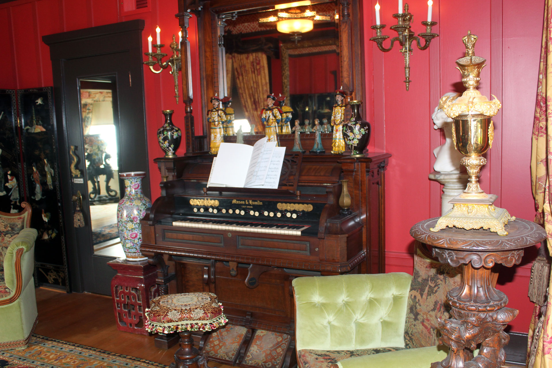 An ornately decorated room with a harmonium, a pump organ, dominating.