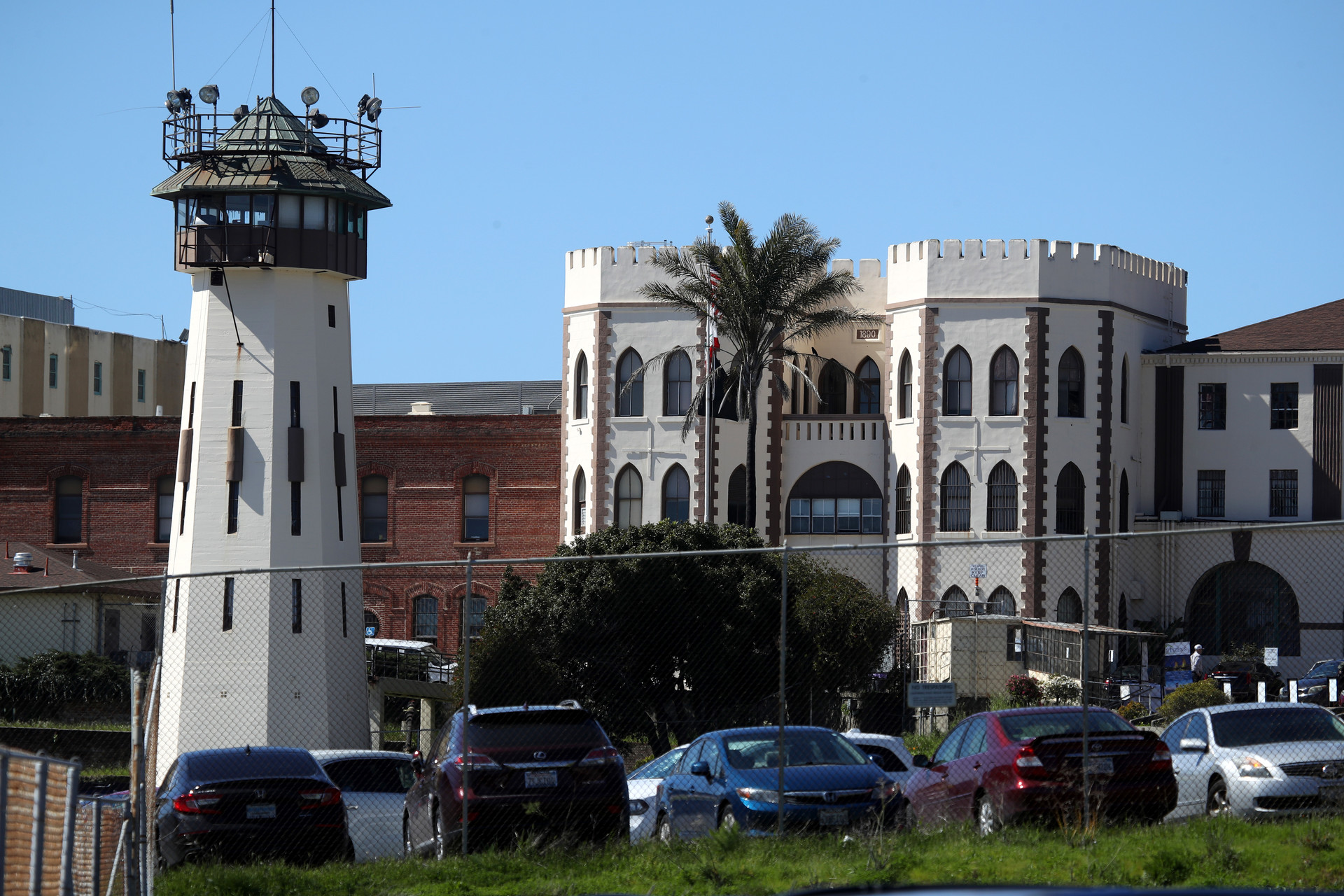 The white turret-like facade and guard toward of the prison, beyond the parking lot.